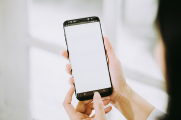 Women hands holding phone with isolated screen on background of window