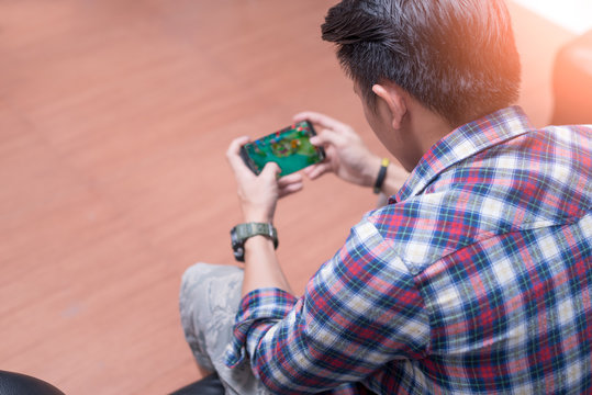 The abstract image of the asian gamer playing video game by the smartphone. the concept of activities, gaming, technology, lifestyle, education, e-sport and internet of things.