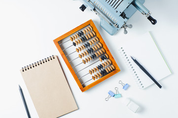 Old wooden abacus and calculating machines isolated on white background. Flat lay and top view. Business or accounting concept