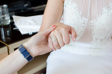 Obraz na płótnie Canvas woman holding hand of a bride while preparing for the wedding