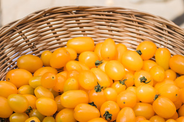 close up fresh yellow cherry tomat in basket.