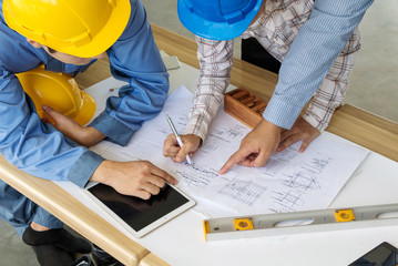 A group of engineers are looking at a blueprint for construction.