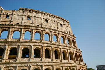 Fototapeta na wymiar Part of the Coliseum against the blue sky Rome, Italy