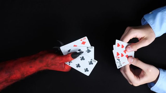 Businessman playing card with the devil.
