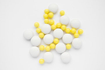 White and yellow pills on white background