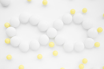 Infinity symbol made of pills , white and yellow pills on white background