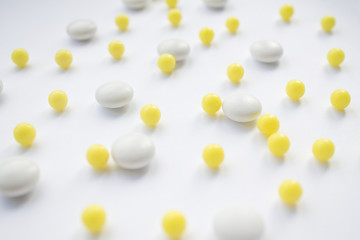 White and yellow pills on white background