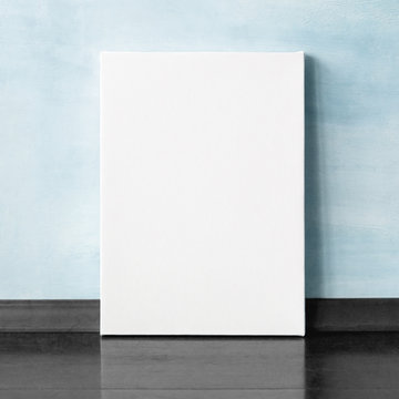 Mock-up poster in the interior. Blank vertical canvas. Blue wall on background.