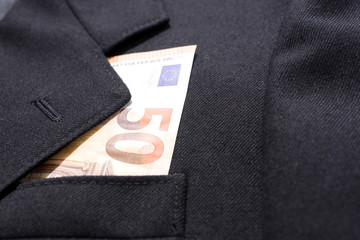 Fifty euros banknote in business man black suit pocket