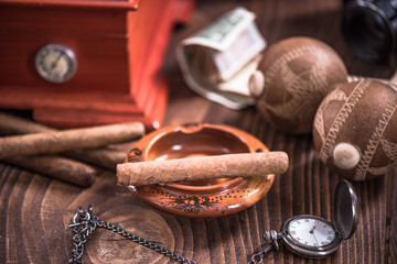 Cuban cigar in ashtray on wooden table