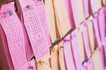 Predicted paper for answer of Fortune Sticks or Seam-si or Kau cim hanging on the wall in a chinese temple, Bangkok, Thailand.