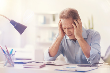 Depressed male office worker having a headache