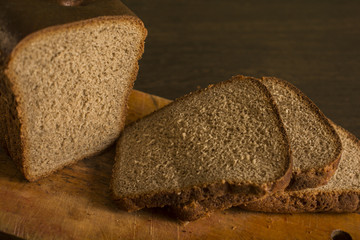 Black gray bread on a board with a knife