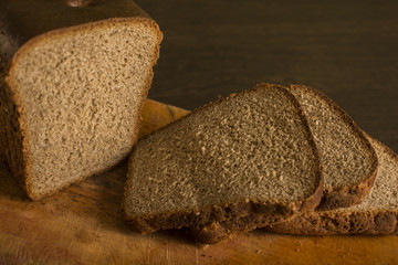 Black gray bread on a board with a knife