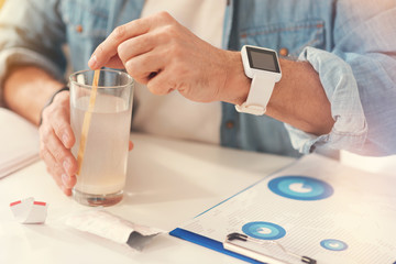Close up of sick man dissolving medicines in the glass of water