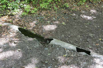 Damaged drainage pipes on the forest path.