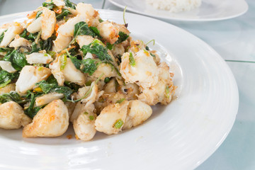 Fototapeta na wymiar spicy crab stir fry with basil and chili on white dish, closeup shot