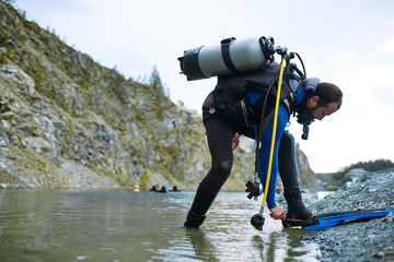 Male diver in wetsuit checking equipments before immerse © sata_production