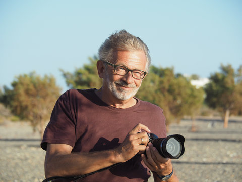 Älterer bärtiger Mann Mann genießt das Leben auf Reisen mit seiner Kamera und einem Lächeln