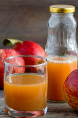 Fototapeta na wymiar Apple juice and fresh apples on a wooden background.