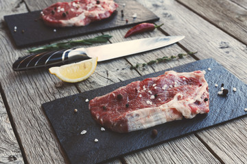 Raw beef steak on dark wooden table background