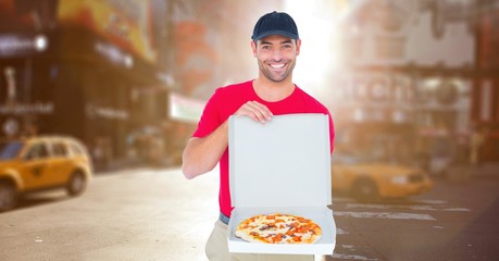 Delivery man with pizza against blurry street with flares