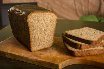 Black gray bread on a board with a knife