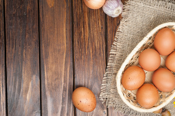chicken eggs in basket decorated with food ingredients on wooden table