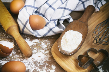 Fototapeta na wymiar Eggs, flour, rolling pin, shape, corolla, baking ingredients with a copy of a stretch in a vintage style