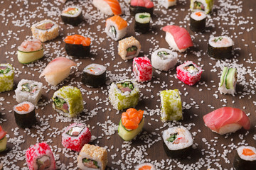 Set of sushi, maki and rolls with sesame on wooden rustic background