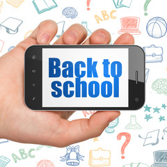 Education concept: Hand Holding Smartphone with Back to School on display
