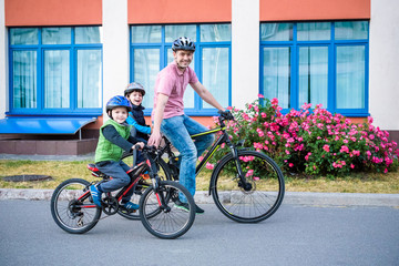 Family cycling, father with happy kid riding bike outdoors