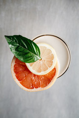 Summer alcoholic cocktail garnished with blood orange and basil