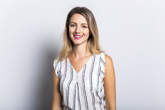 Young Woman Leaning Against Gray Wall Background