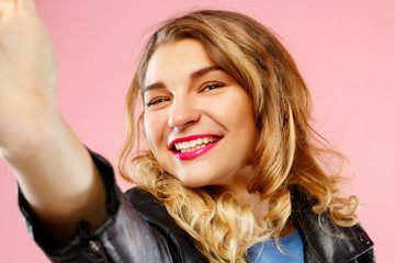 Naklejka premium Portrait of a beautiful young woman making selfie on smart phone. Happy young woman photographing herself.