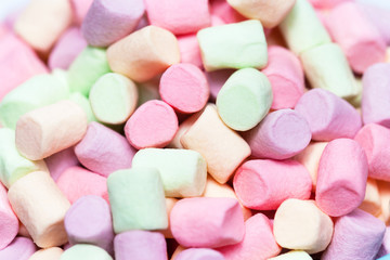 Colorful mini marshmallows background macro. Fluffy marshmallows texture and pattern. Flat lay or top view. Winter food background concept.