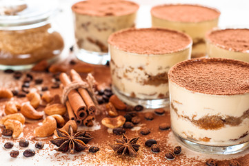 Homemade tiramisu, traditional Italian dessert in glass on white wooden table