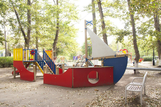 Children's playground in the courtyard of the house (swings, slides).  Bright, juicy photos of a children's playground in the courtyard of a residential building. Children swing, carabolic.