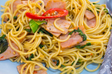 fusion food, spaghetti with fried crispy bacon ,sausage and basil leave, hot and spicy food, international cuisine