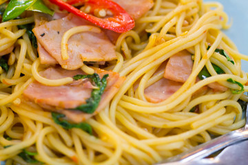 fusion food, spaghetti with fried crispy bacon ,sausage and basil leave, hot and spicy food, international cuisine