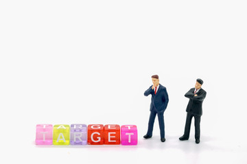 Business and Idea concept. Two businessman miniature people figures standing with colorful block english letter 