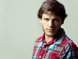 caucasian man wearing checkered shirt and trendy hairstyle