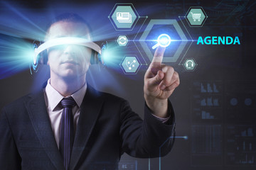 Business, Technology, Internet and network concept. Young businessman working in virtual reality glasses sees the inscription: Agenda