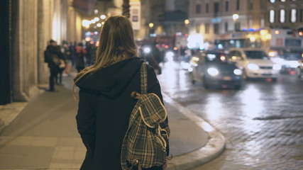 Young traveling woman with backpack crossing the traffic road, tourist looking around and find the...
