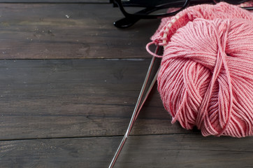 knitting threads and glasses  on a wooden table.