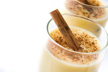 Homemade eggnog with cinnamon isolated on white background. Typical Christmas dessert.
