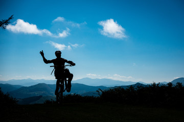 basque mountain bike wheelie silhouette with mountain view - obrazy, fototapety, plakaty