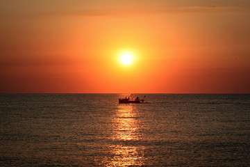 Naklejka na ściany i meble On the boat through the sunset