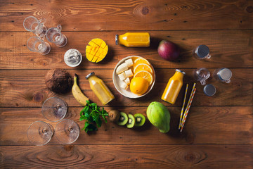 Yellow smoothie, Variety of fresh fruits for healthy eating or making yellow or green smoothie over rustic wooden background, top view. Healthy eating, vitamin, detox, diet food, clean eating concept