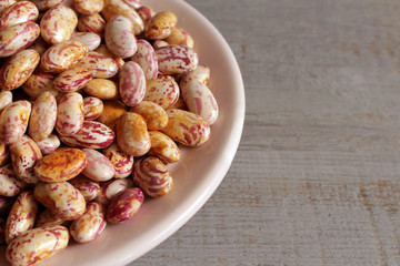 Dry White Beans on a plate on wooden background.